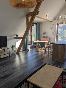 a living room with wooden floors and a table at Appartement La Rose des Vents in Lautenbach