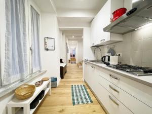 een keuken met witte kasten en een fornuis met oven bij Il Desiderio zona Piazza del Campo in Siena
