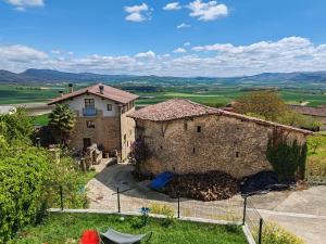 an external view of a stone house with mountains in the background at Caserío `The Formicary´ in Antezana de la Ribera