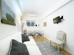 een woonkamer met een witte bank en een tafel bij Il Desiderio zona Piazza del Campo in Siena