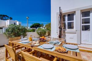 a wooden table with food on it on a patio at Villa Oliveiras de Vilamoura by The Portuguese Butler in Quarteira