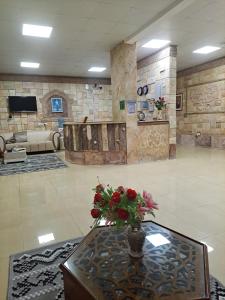 um lobby com uma mesa com um vaso de flores em Dream Barka Hotel em Barka