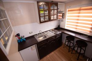 an overhead view of a kitchen with a sink and stools at Hostal Terraza Recreo in Viña del Mar