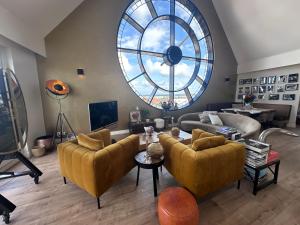 a living room with couches and a large window at Villa Beukenhof in Oegstgeest