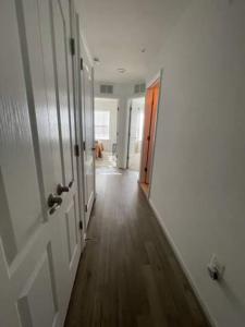 um corredor com uma porta aberta com um cão ao fundo em 3 beautiful Bedroom Townhome em Germantown