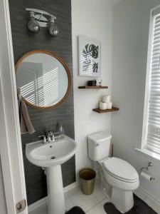een badkamer met een wastafel, een toilet en een spiegel bij 3 beautiful Bedroom Townhome in Germantown