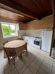 Saint-Jean-de-ThurigneuxにあるChez Paulのテーブルと白い冷蔵庫のあるキッチン