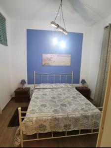1 dormitorio con 1 cama con pared azul en TERRA MIA en Marsala