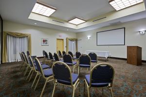 a conference room with chairs and a white screen at La Quinta by Wyndham Houston New Caney in New Caney