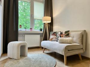 - un salon avec un canapé et une chaise dans l'établissement Park House Apartament Deluxe- free parking, à Częstochowa