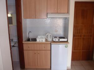 a small kitchen with a sink and a stove at Vazakas Rooms in Mytilene