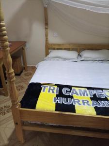 een bed in een kamer met een bord erop bij Merricks Guest House in Litein