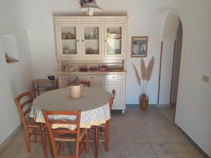 een keuken met een tafel en stoelen en een tafel en kasten bij Trullo Il Giglio in Cisternino