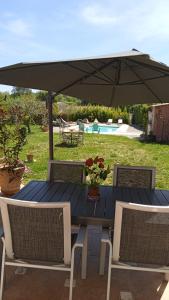 a blue table with chairs and an umbrella at T2 au calme avec piscine in Néoules