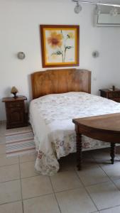 1 dormitorio con cama y mesa de madera en T2 au calme avec piscine, en Néoules