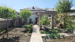 a garden in front of a house with trees at Halal House VİP in Qusar