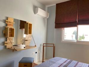 sypialnia z łóżkiem i lustrem na ścianie w obiekcie Appartement simple et propre w mieście Safakis