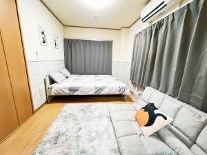 salon z łóżkiem i kanapą w obiekcie 西武新宿線 駅近4人可 02 w Tokio