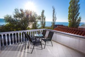 einen Balkon mit einem Tisch, Stühlen und Meerblick in der Unterkunft Apartments Petar in Rtina