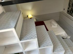 マドリードにあるGenial Estancia en Madrid centroの二段ベッド2台、ランプ付きのベッド1台が備わる客室です。