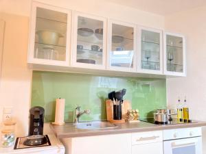 Una cocina con gabinetes blancos y un fregadero. en SuperHosts ZENTRUM - Küche - NETFLIX - Kaffee, en Bremen