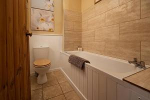 une salle de bain avec toilettes et baignoire avec lavabo dans l'établissement Castle Cottage, Press Mains Farm Cottages, à Eyemouth 17 autres photos