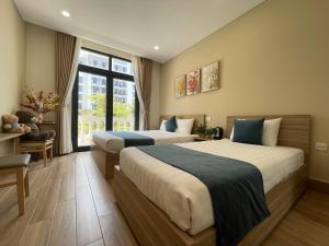a hotel room with two beds and a window at Teddy 96 Homestay & Cafe-3 stars-Grand World Phu Quoc in Phu Quoc