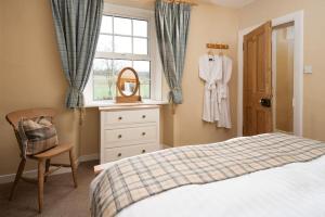 une chambre avec un lit, une commode et une fenêtre dans l'établissement Castle Cottage, Press Mains Farm Cottages, à Eyemouth