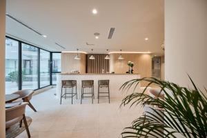 a kitchen with a bar with stools in it at Aqua Vista Infinity Resort & Spa - Studio Lux - Piscină Infinity, Jacuzzi, Sauna, Gym - Privat in Mamaia Sat/Năvodari
