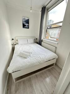 Cama pequeña en habitación pequeña con ventana en Bell street, en Londres