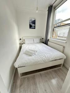 Ce lit se trouve dans une petite chambre dotée d'une fenêtre. dans l'établissement Bell street, à Londres