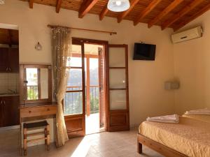 a bedroom with a bed and a sliding glass door at Valmas village in Skiathos Town