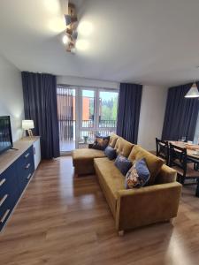 a living room with a couch and a dining room at Apartament przy tężni in Augustów