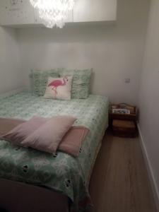 een slaapkamer met een bed met een roze flamingo-kussen bij Vittoria Immobilier 10 -Vue Dégagée - Terrasse - chèques vacances acceptés in La Grande-Motte