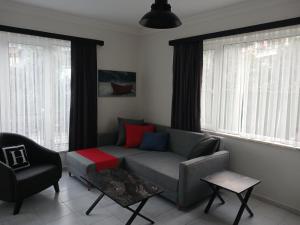 a living room with a couch and a chair at Hanlı Apart Otel in Muğla