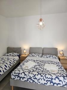 a bedroom with two beds and a light fixture at Bassa Marea in Grottammare