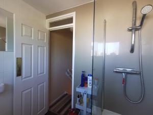 La salle de bains est pourvue d'une douche et d'une porte en verre. dans l'établissement AW House, à Édimbourg