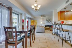 a dining room and living room with a table and chairs at Pensacola Beach Condo with Patio and Access to Beach! in Pensacola Beach