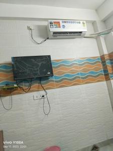 a laptop on a wall in a room at Raghav guest house in Mathura