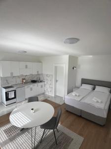 a white room with a bed and a table and chairs at Saraapartmani in Plav