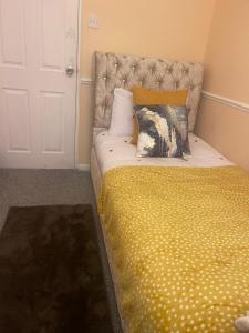 łóżko z żółtą pościelą i poduszkami w pokoju w obiekcie Modern 3 Bed House for 6 guests w mieście Nevendon