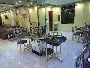 um restaurante com mesas e cadeiras num quarto em Hotel Shobhani em Deoghar