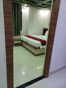 a bedroom with a bed and a mirror at Hotel Shobhani in Deoghar