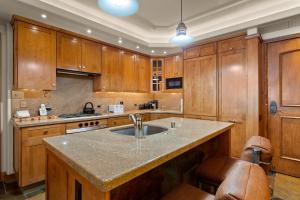 a kitchen with wooden cabinets and a large sink at Bridge Street - Unit 202 in Vail
