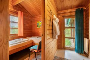 a log cabin bedroom with a bed and a window at Hüssli Numero 1 in Hayingen