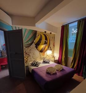 Cette chambre comprend un lit avec des draps violets et une fresque murale. dans l'établissement Il Giardino del Viaggiatore, à Rome