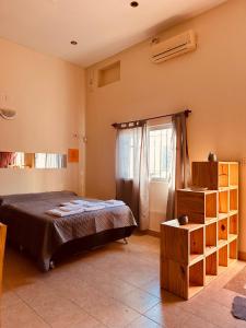 un dormitorio con una cama y una ventana en Quenti apart salta, en Salta