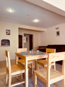 Un comedor con mesa y sillas de madera. en Quenti apart salta, en Salta
