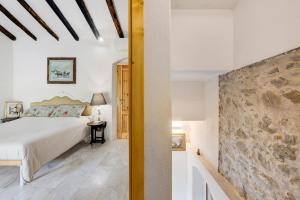 ein Schlafzimmer mit einem Bett und einer Steinmauer in der Unterkunft Villino Marco in Luni