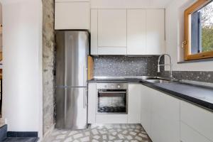 a kitchen with white cabinets and a stainless steel refrigerator at Villino Marco in Luni